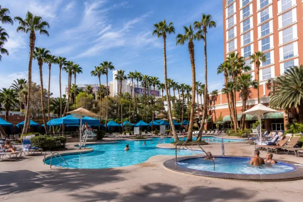 The tropical outdoor pool at Treasure Island Hotel & Casino is surrounded by palm trees and resort seating in Las Vegas.