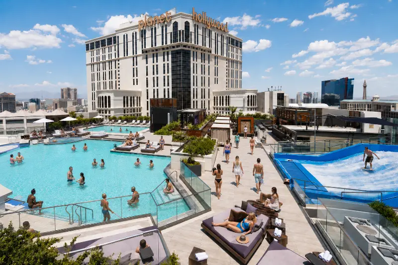 Guests relax beside two pools and the wave-riding attraction at The Scene Pool Deck at Planet Hollywood in Las Vegas.