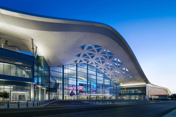 Exterior of Las Vegas Convention Center on Paradise Road with sweeping curved roof, glass facade, and geometric lattice design at entrance