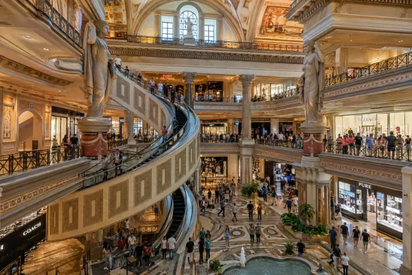 Shoppers ride the spiral escalators through the multilevel Roman-inspired interior of The Forum Shops at Caesars Palace in Las Vegas.