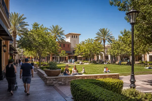 Families and shoppers gather near Town Square Park amid landscaped walkways and storefronts at Town Square Las Vegas.