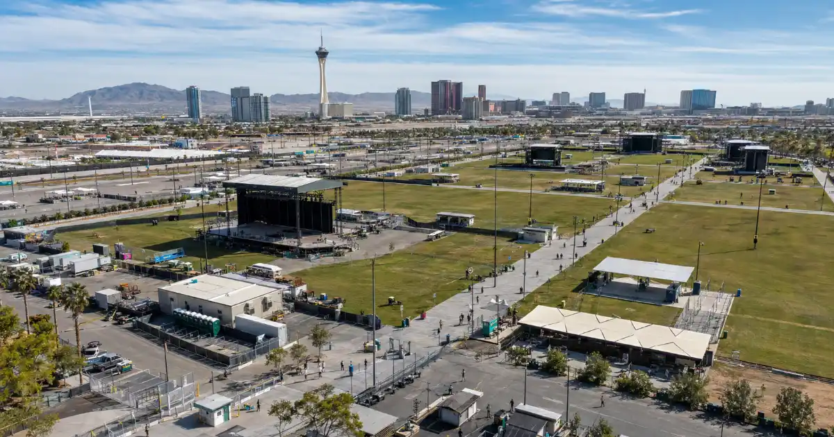 An elevated daytime view of stage structures and open event space at Las Vegas Festival Grounds near the north end of the Strip.