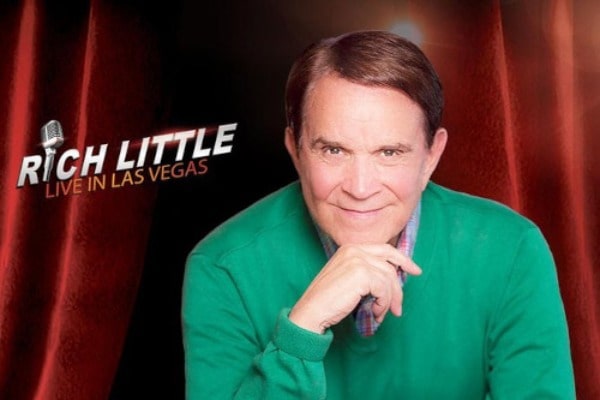 A promotional image for Rich Little Live, showing the performer on a stage with a red curtain behind him and a spotlight on him.