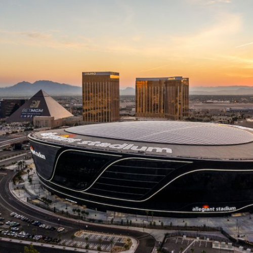 Allegiant Stadium at dusk with Las Vegas Strip behind