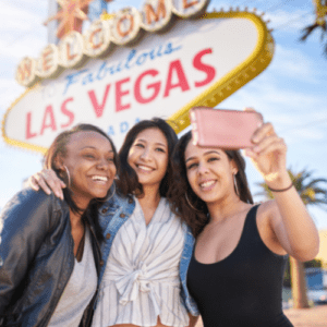 Group of 3 girl friends taking a selfie in front of the welcome to fabulous Las Vegas Sign