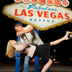 Couple posing in front of the welcome to fabulous Las Vegas Sign at night