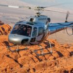 a helicopter flying over the red rock canyon