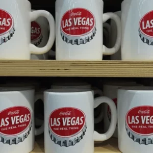 This is a picture of a shelf of Coca Cola Mugs at Coca Cola World store in Las Vegas