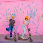 A couple rides their rental scooters in downtown Las Vegas