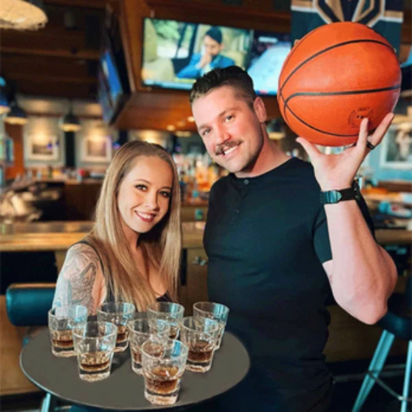 An image of a cocktail waitress and a customer at a PTs Basketball Game Watch Party