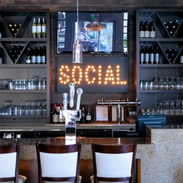 This is a picture of the bar with seating and wine bottles at the Vita Bella Wine Bar and Social Club at the Ahern Hotel in Las Vegas