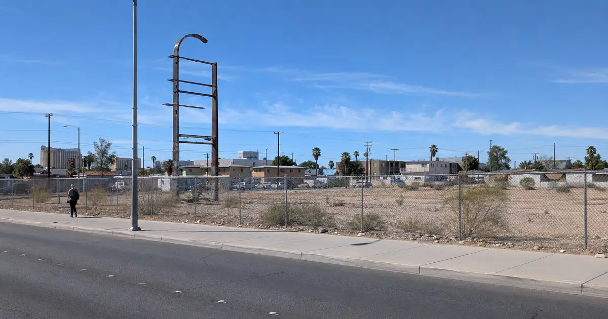 A fenced vacant parcel and weathered sign frame mark the current Moulin Rouge Historic Site in Las Vegas.