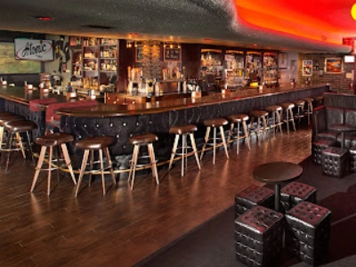 interior of atomic liquors dive bar in las vegas with retro bar counter warm lighting and vintage decor