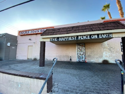 exterior of double down saloon dive bar in las vegas with graffiti entrance and happiest place on earth signage