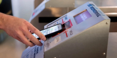 Passenger scanning mobile ticket at Las Vegas Monorail fare gate with contactless QR code reader