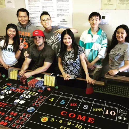 Graduates of the PCI Dealer School in Las Vegas pose in front of a craps table
