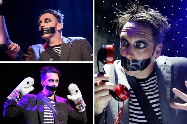 A promotional image for the Tape Face show, showing the performer with black tape over his mouth, with a spotlight on him and a crowd of people behind him.