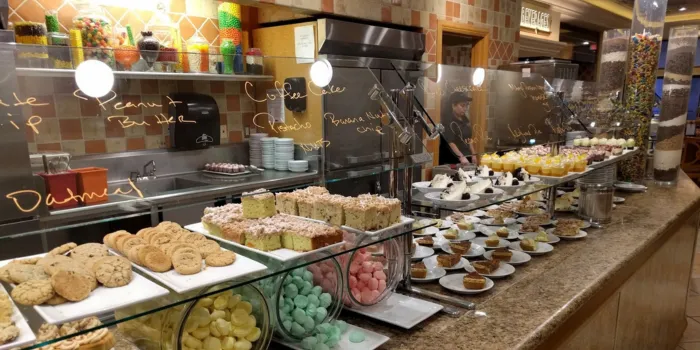The dessert and bakery station at the MGM Grand Buffet in Las Vegas, featuring a wide selection of cookies, cakes, pastries, and a colorful candy display.
