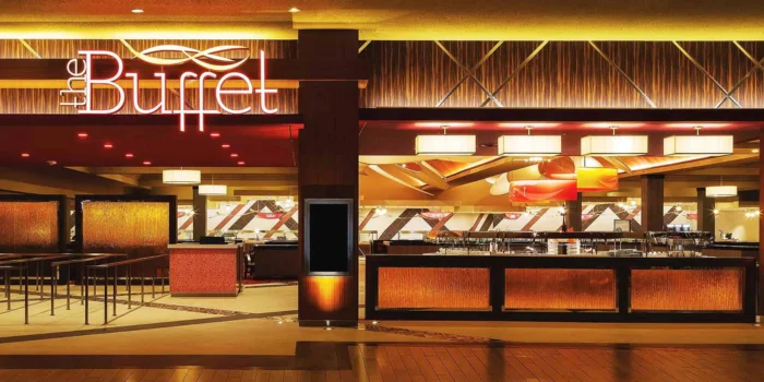 The exterior entrance of The Buffet at the Excalibur Hotel in Las Vegas, showing the glowing "the Buffet" sign and the queueing area for guests.