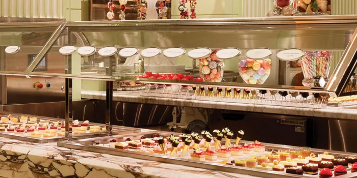 The luxurious dessert station at The Buffet at Wynn Las Vegas, featuring a wide selection of gourmet, artfully-arranged cakes, pastries, and tarts on a beautiful marble countertop.