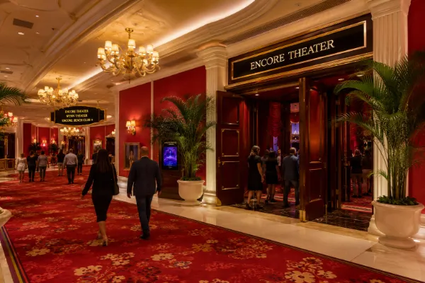 Red carpeting, chandeliers, palms, and formal entry doors line the approach to Encore Theater at Wynn Las Vegas.