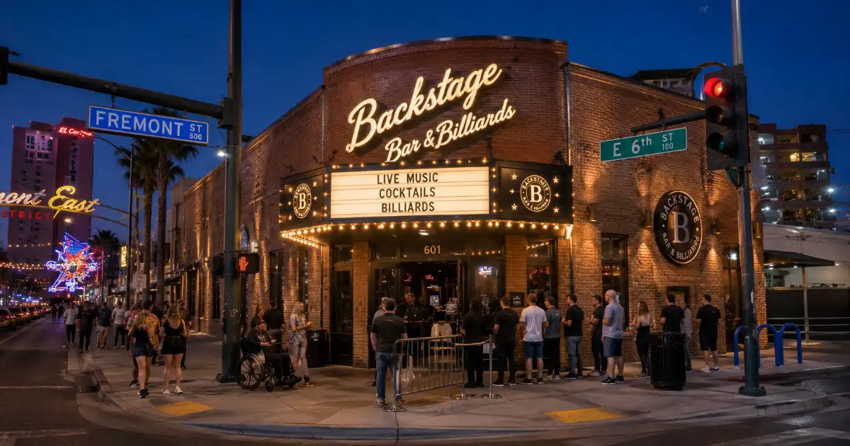 Adult concertgoers arrive beneath the illuminated marquee at Backstage Bar & Billiards in Downtown Las Vegas.