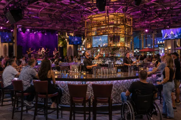 Flair bartenders entertain adult guests beside the live-music stage at Carnaval Court in Harrah's Las Vegas.