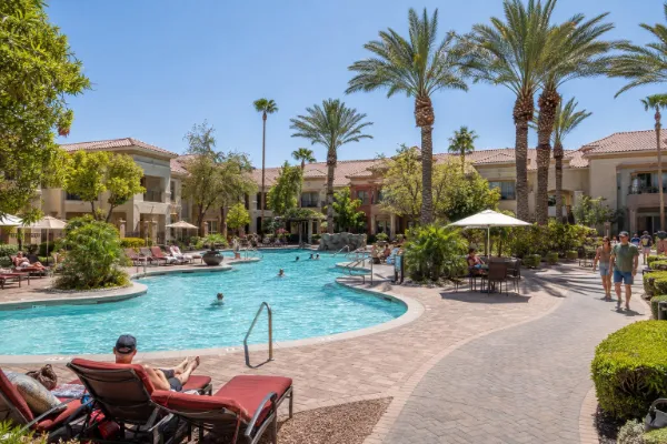 The lagoon-style pool at Tuscany Suites & Casino sits among palm trees and low-rise red-tile-roofed resort buildings in Las Vegas.