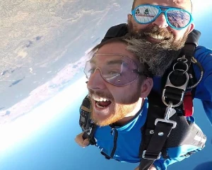 A man is tandem skydiving at the Grand Canyon