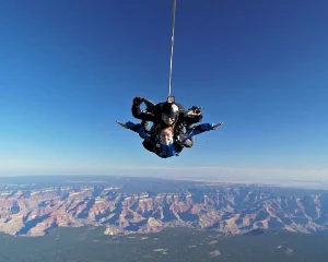 A man is tandem skydiving over the Grand Canyon