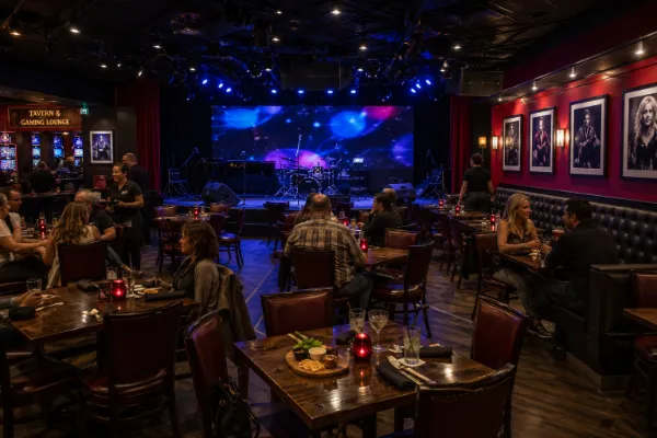 Guests gather at tables facing the intimate stage and LED video wall inside The Composers Room in Las Vegas.