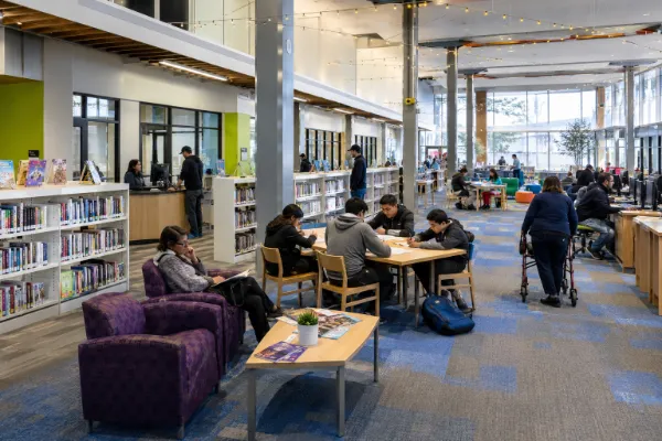 Children and adults read, study and use computers inside the bright open interior of East Las Vegas Library.