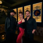 Three cabaret performers stand for a photo in a luxurious lounge in Las Vegas.
