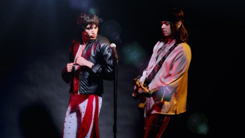 Image for the Sin City Stones tribute show, showing the two lead performers, Drew Johnson and Andrew Stasi, on a stage with a crowd in the background.