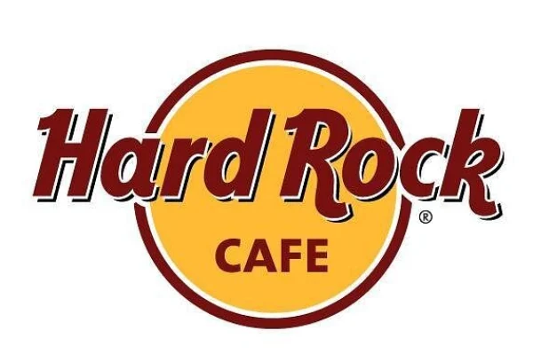 Hard Rock Cafe logo featuring bold red "Hard Rock" text with white outline over a yellow circle, with "CAFE" in smaller red font below—iconic branding for the global music-themed restaurant chain.