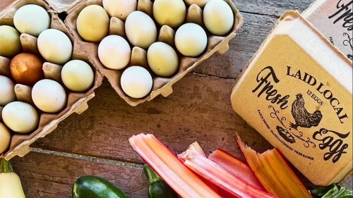Farm-fresh eggs and colorful vegetables on rustic table at Rose Creek Farm farmers market in Las Vegas