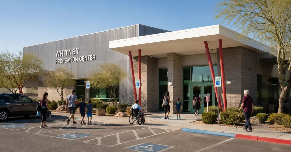 Visitors approach the accessible entrance and distinctive red-columned exterior of Whitney Recreation Center in Las Vegas.