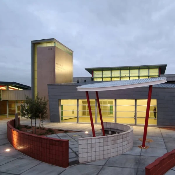 Whitney Recreation Center in Las Vegas featuring modern architecture with red angled columns, circular canopy, and landscaped entrance