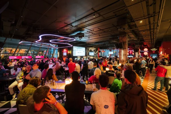 Formula One Grand Prix viewing party at F1 Arcade Las Vegas with crowd neon lights large screens and festive social atmosphere