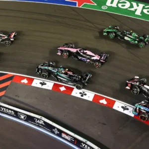 Formula 1 Las Vegas Grand Prix main race on Saturday with multiple cars navigating themed track featuring playing card symbols and Vegas branding