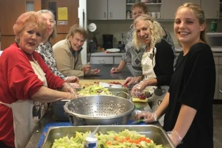 volunteers preparing salad and meals in kitchen for friends in the desert food assistance program at st timothys episcopal church in henderson nevada