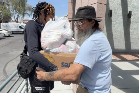 jfsa volunteer handing box of food bags to community member outside jewish family service agency in las vegas