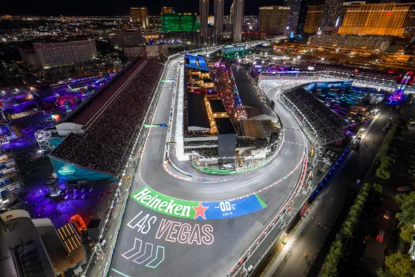 Nighttime aerial view of Formula 1 Las Vegas Grand Prix race circuit with illuminated track grandstands and Las Vegas Strip skyline