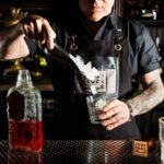 Bartender preparing cocktail during mixology demonstration in Las Vegas with ice and red liquor