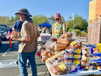 volunteers distributing bread and baked goods at lutheran social services of nevada food pantry event in las vegas parking lot