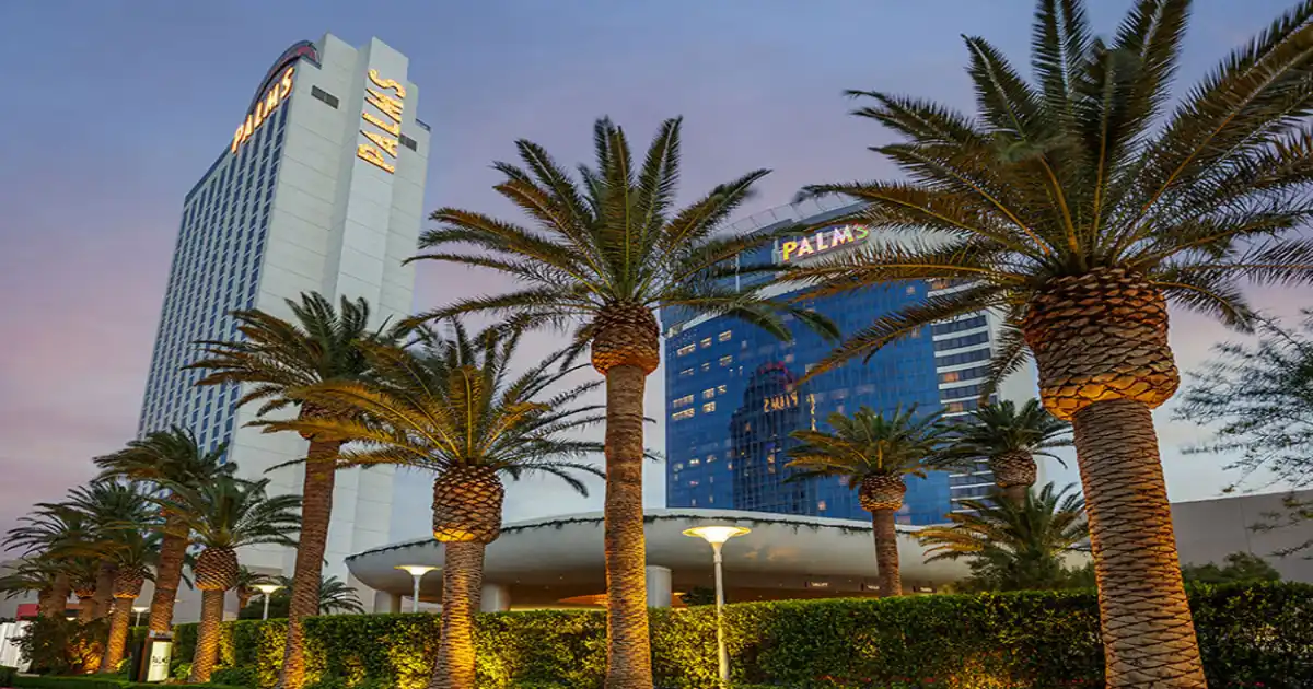 The illuminated towers and main entrance of Palms Casino Resort in Las Vegas at twilight.