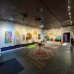 Las Vegas Arts District gallery with colorful paintings, disco ball, and whimsical decor—First Friday exhibition space
