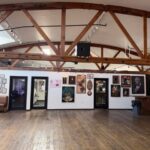 Las Vegas Arts District gallery with framed artwork, exposed beams, and cozy seating—First Friday creative space