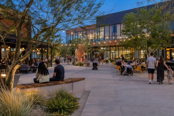 Visitors dine and relax among shaded seating, public art, and landscaped walkways in The Quad at UnCommons Las Vegas.