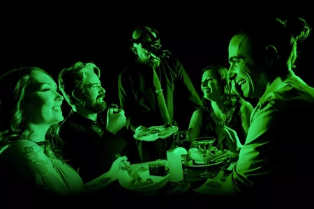 vegan dining in the dark experience with guests eating and person in gas mask at blackout restaurant in las vegas